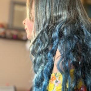 a woman with blue hair and a yellow shirt